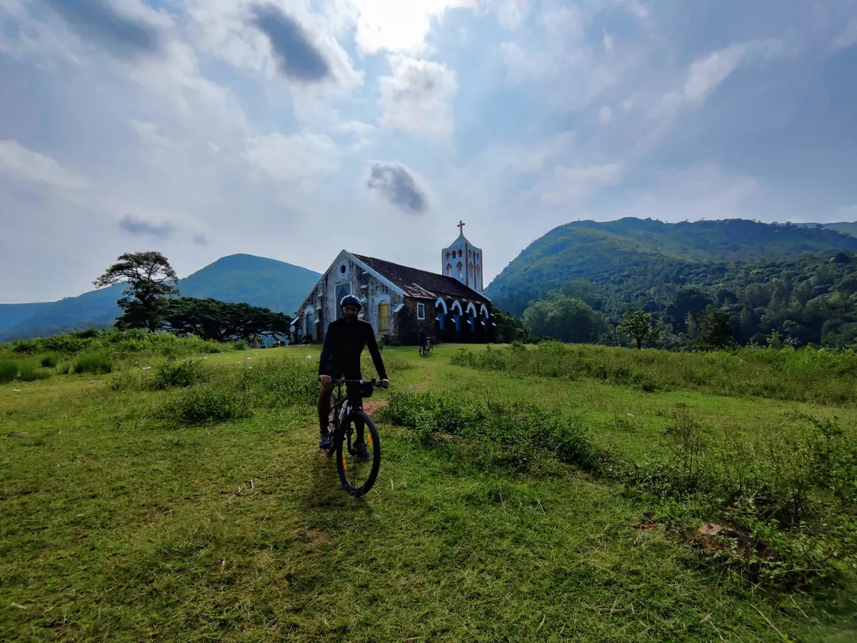Cyclist in front of a hill church